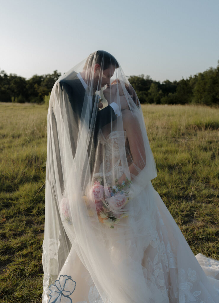 Bride and groom under a veil in Austin Texas at their wedding